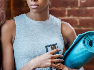 A bottle of water next to a rolled-up exercise mat.